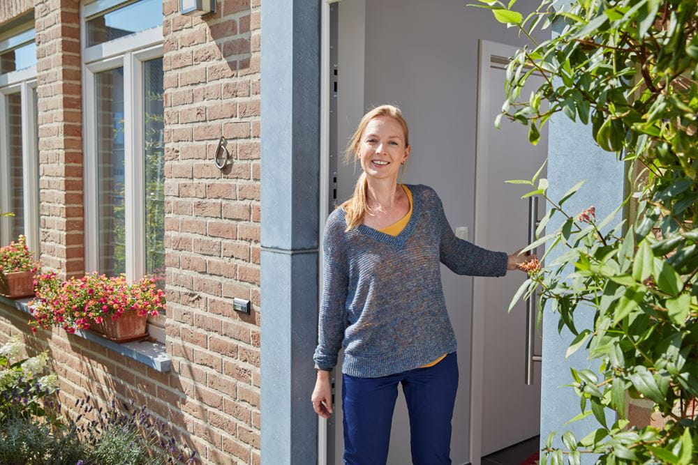 Vrouw doet deur van kijkwoning open