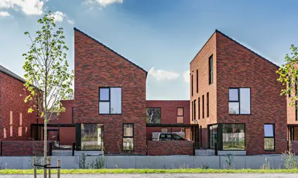 deurne eksterlaer patiowoningen vooraanzicht daken groen bomen ramen blauwe lucht